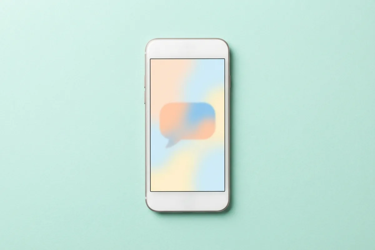Smartphone on a mint background showing an abstract chat bubble